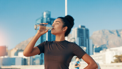 Woman, fitness or drinking water in city for break, natural sustainability or refreshment. Active, female person or thirsty runner with mineral liquid or aqua beverage for hydration, recovery or rest