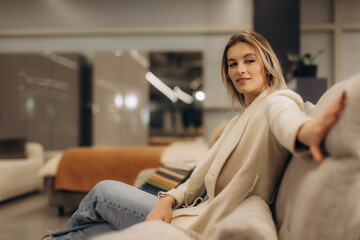 Obraz premium Woman Relaxing on a Comfortable Sofa in a Modern Stylish Living Room