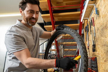 Mechanic in black gloves gripping wheel