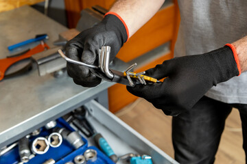 Mechanic in black gloves adjusting tools