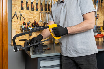 Mechanic working with hacksaw