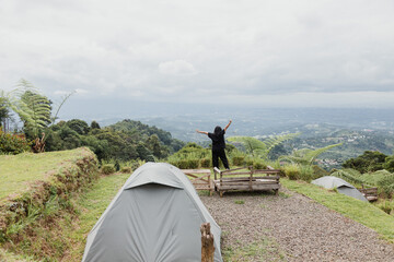 a happy girl camping at the mountains
