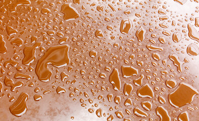 A brown surface with many small drops of water on it