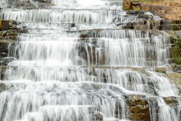 Beautiful Cascading Pongour Waterfall Over Rocky Terraces in sunlight. Lam Dong Province, Vietnam.