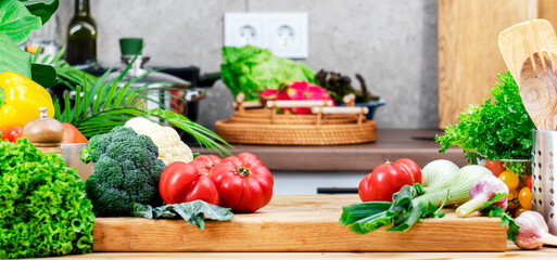 Food background. Healthy eating, cooking, blogging scene. Cutting board with raw tomatoes, vegetables and herbs on wooden table in comfy kitchen with kitchenware and utensils