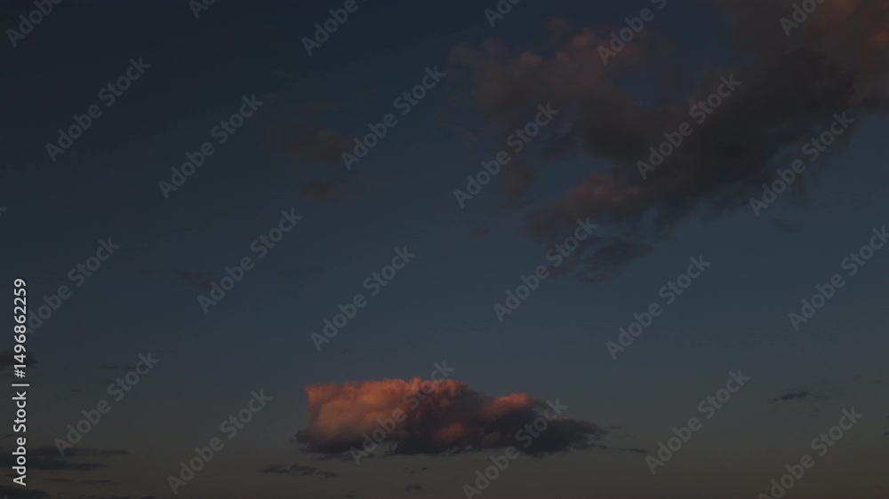 Poster a low angle time lapse, looking up at clouds floating away from the camera, with the golden glow of 