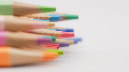 a crisp, sharp pink pencil tip in the foreground while the rest blur into soft color behind it. It evokes motion, progression, or even emergence from chaos into clarity