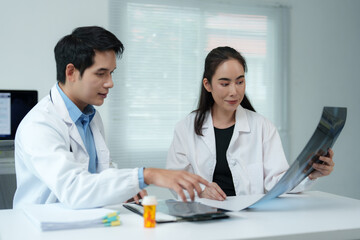 Doctors examining x ray scan discussing diagnosis in hospital office