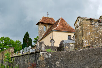 View of the White Penitents Chapel and cemetery on a hill near the village of Cornac Lot Occitanie in Southern France in summer under a cloudy sky	