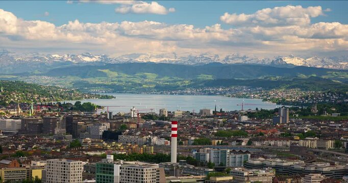 16-05-2025 Zurich, Switzerland. Time lapse footage of the city as seen from hilltop outlook point. Cloudy summer day, Snowy Alps and lake Zurich in the background, real time footage