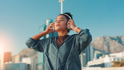 City, fitness and music with woman outdoor for break from cardio or running routine. Exercise, headphones and streaming with athlete or runner in urban town for marathon, sports or workout challenge © Claytonon/peopleimages.com