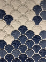 Fototapeta premium Seamless scallop shell ceramic tiles in white and navy blue tones, creating a textured ocean-inspired pattern perfect for interior design and coastal decor themes.