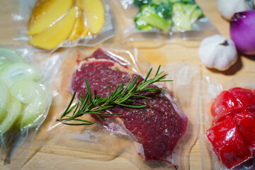 Sealer for vacuum packing with plastic bag of raw meat on wooden table, to preserve meat, flat lay, top view.