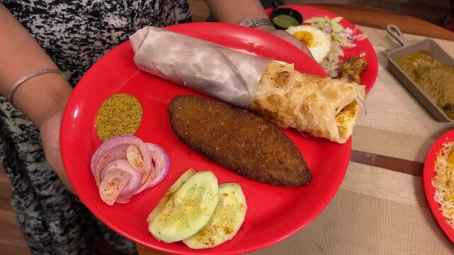 Bengali famous street food egg roll and fish cutlet served in red plate