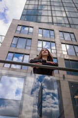 Portrait of a beautiful woman against the background of a modern high-rise building.