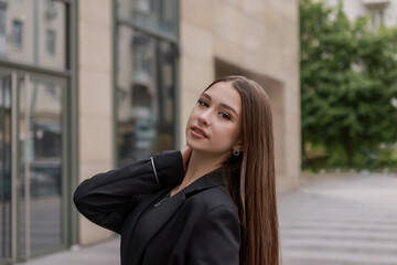 Obraz premium Portrait of a beautiful brunette in a classic jacket on a city street.