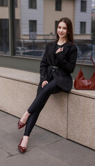 Beautiful girl in patent burgundy shoes against the background of a business center.