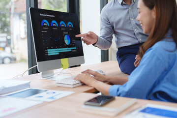 Business people analyzing financial charts and graphs on computer screen in office meeting