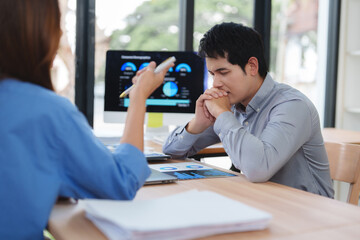 Businessman stressed and worried about falling sales charts on computer screen