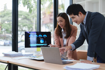 Business people analyzing financial charts and graphs on laptop and computer screen