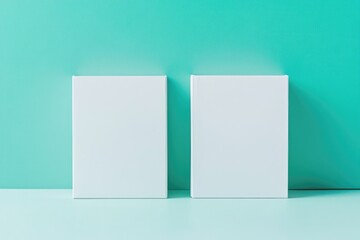 Naklejka premium Two blank white canvases or boxes against a teal wall