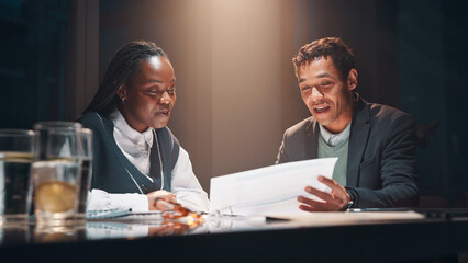 Discussion, paperwork and business people at night meeting for overtime, planning or research. Creative startup, late collaboration or man with woman for project, proposal and brainstorming in office