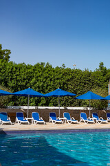 Blue pool with sunbeds and umbrellas at a hotel