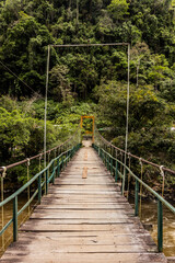 Hanging bridge over Huallaga river near Catarata Gloriapata waterfall in Tingo Maria national park, Peru