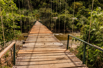 Hanging bridge over Huallaga river near Catarata Gloriapata waterfall in Tingo Maria national park, Peru