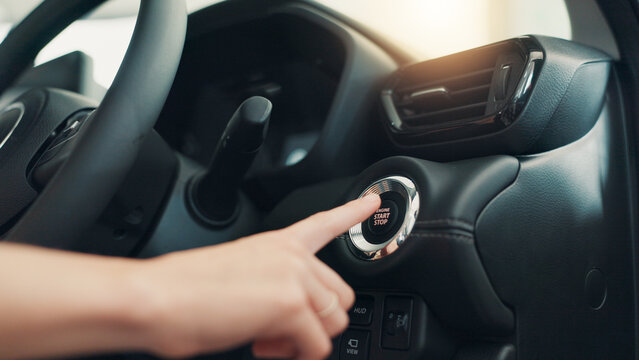 Hand, press button and start car for travel, journey and test drive with keyless tech. Electric ignition, person and push switch for engine power, transport innovation or stop motor vehicle closeup