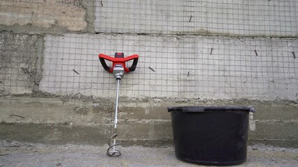 Construction tools for mixing mortar or concrete near a reinforced concrete wall