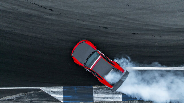 Aerial top view high speed car drifting on asphalt race track with lots of smoke from burning tires, Professional driver drifting car,  Car drift motorsport car drifting race.