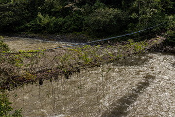 Broken hanging bridge over Huallaga river in Honolulo village near Tingo Maria, Peru