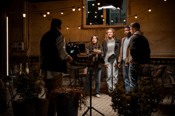 Obraz premium Outdoor group photoshoot during evening light at a cozy location with string lights in the background