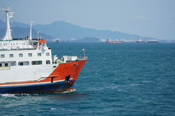 Container Ship Navigating Through Calm Ocean Waters Near Coastal Mountains