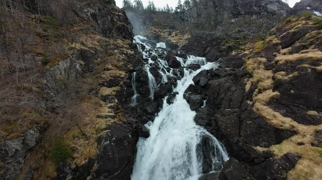 FPV Drone Shot of Latefossen Waterfall from Gronsdalslona River Rapids, Norway, Ascending Aerial View