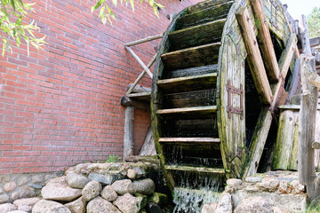 Working watermill wheel with falling water in the village. © Garik