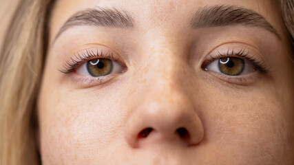 Close-up portrait of a woman after eyelash lamination procedure. 