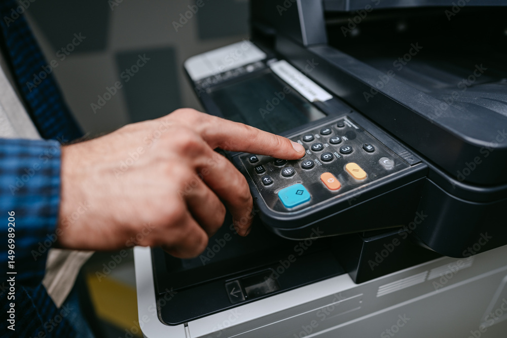 Poster man using a multifunction printer to operate the control panel in an office environment during worki