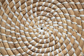 Straw round brown stand for dishes in the kitchen as a background, straw wicker