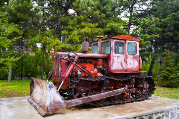 Obraz premium An old rusty tractor stands near the barn