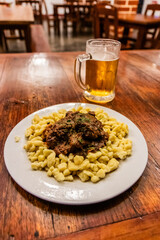 German meal in Pozuzo village, Peru. Goulash with spaetzle and a beer.