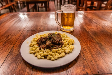 German meal in Pozuzo village, Peru. Goulash with spaetzle and a beer.