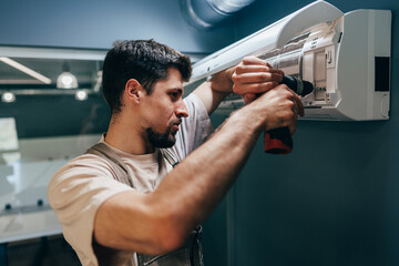 Technician installs air conditioning unit at modern office space during daytime