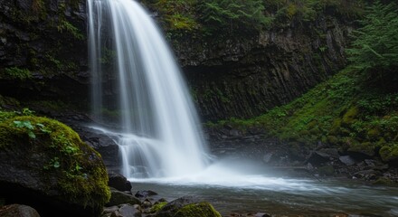Obraz premium Immersive Waterfall Base Shot with Flowing Water and Surrounding Rocks