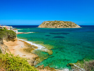 Clear water beach and offshore island where have archaeological remains of Minoan civilisation seen from the heights (Mochlos, Crete, Greece)