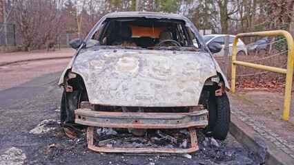 Burnt Electric Car Wreck with Melted Interior and Tires Caused by Battery Fire