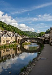 A beautiful view of Dinan, France, with its stone bridge, river reflections, and lush greenery.