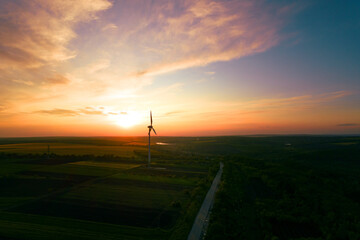 Obraz premium Aerial view of windmill turbines generating green energy electricity at sunset.Green energy helps reduce carbon emissions and makes the earth cleaner and more ecological.Ecology technology industrial.