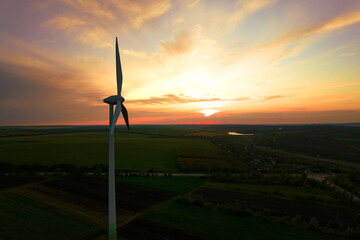 Obraz premium Aerial view of windmill turbines generating green energy electricity at sunset.Green energy helps reduce carbon emissions and makes the earth cleaner and more ecological.Ecology technology industrial.
